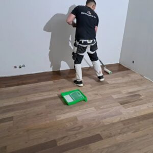 Målare som behandlar och målar golv i renoveringsprojekt